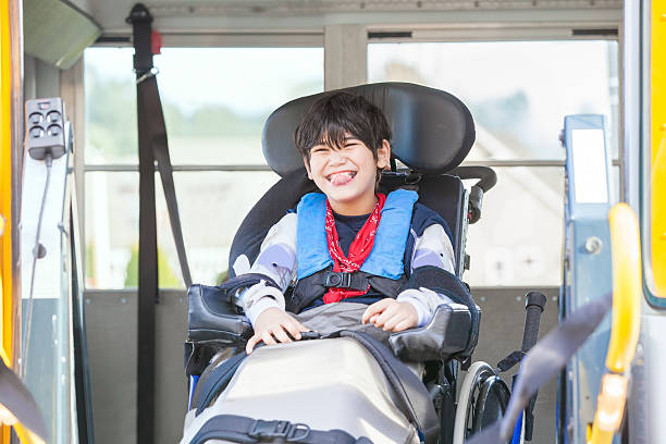 노란 학교 버스 리프트에 휠체어에 미소 장애인 소년 스톡 사진