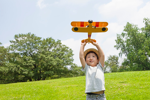 Boy playing with an airplane of a toy in the park
