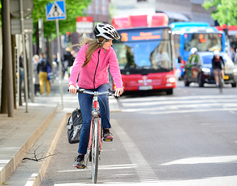 Girl and bicycle, traffic in background