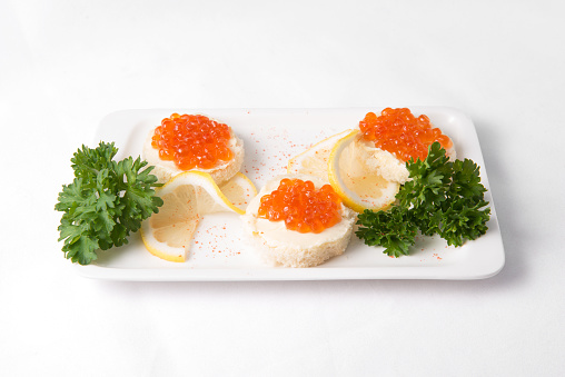 Sandwiches with red caviar on white plate