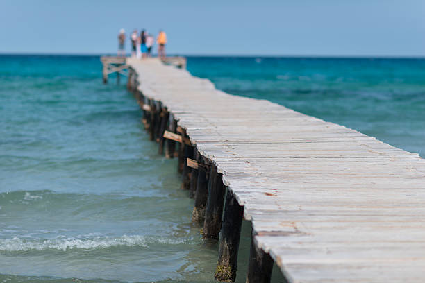 molo di legno in oceano con le persone - sfocato - wood tranquil scene serene people lake foto e immagini stock