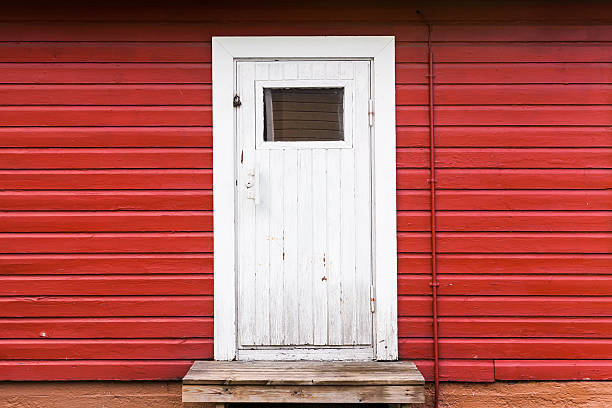 istock Small white closed door in red wooden wall 583978866