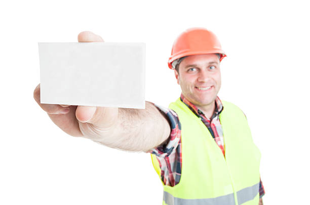Handsome builder showing visit card in close-up stock photo
