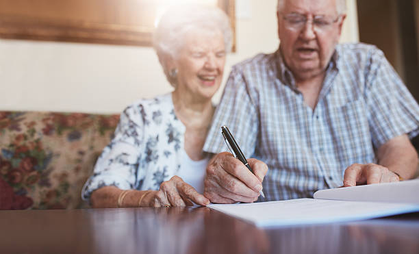 istock Senior couple signing documents at home 583979606