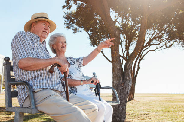 istock Happy senior couple sitting on a park bench 583980024