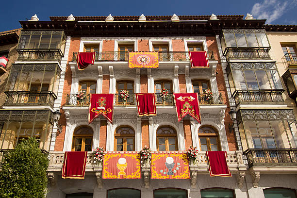 Banners with historical emblems hang from windows of an old building in the Plaza de Zocodover in Toledo, Spain