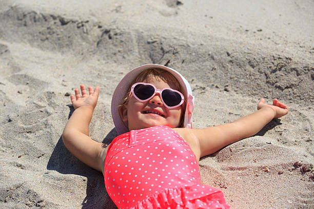 istock cute little girl play on sand beach 583981438