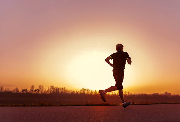 istock Running man silhouette in sunset time 583983930