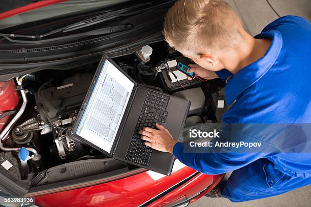 Mechanic Using Laptop To Repair Car Stock Photo - Download Image Now - Auto Mechanic, Mechanic, Car