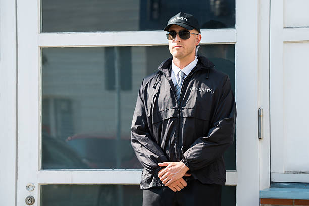 Male Security Guard Standing At The Entrance Young Male Security Guard Standing At The Entrance security guard photos stock pictures, royalty-free photos & images