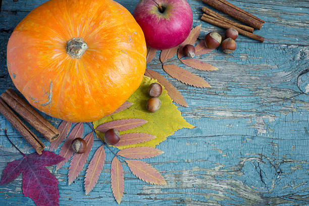 istock Pumpkin, nuts and leaves on the old wooden background. 583985194