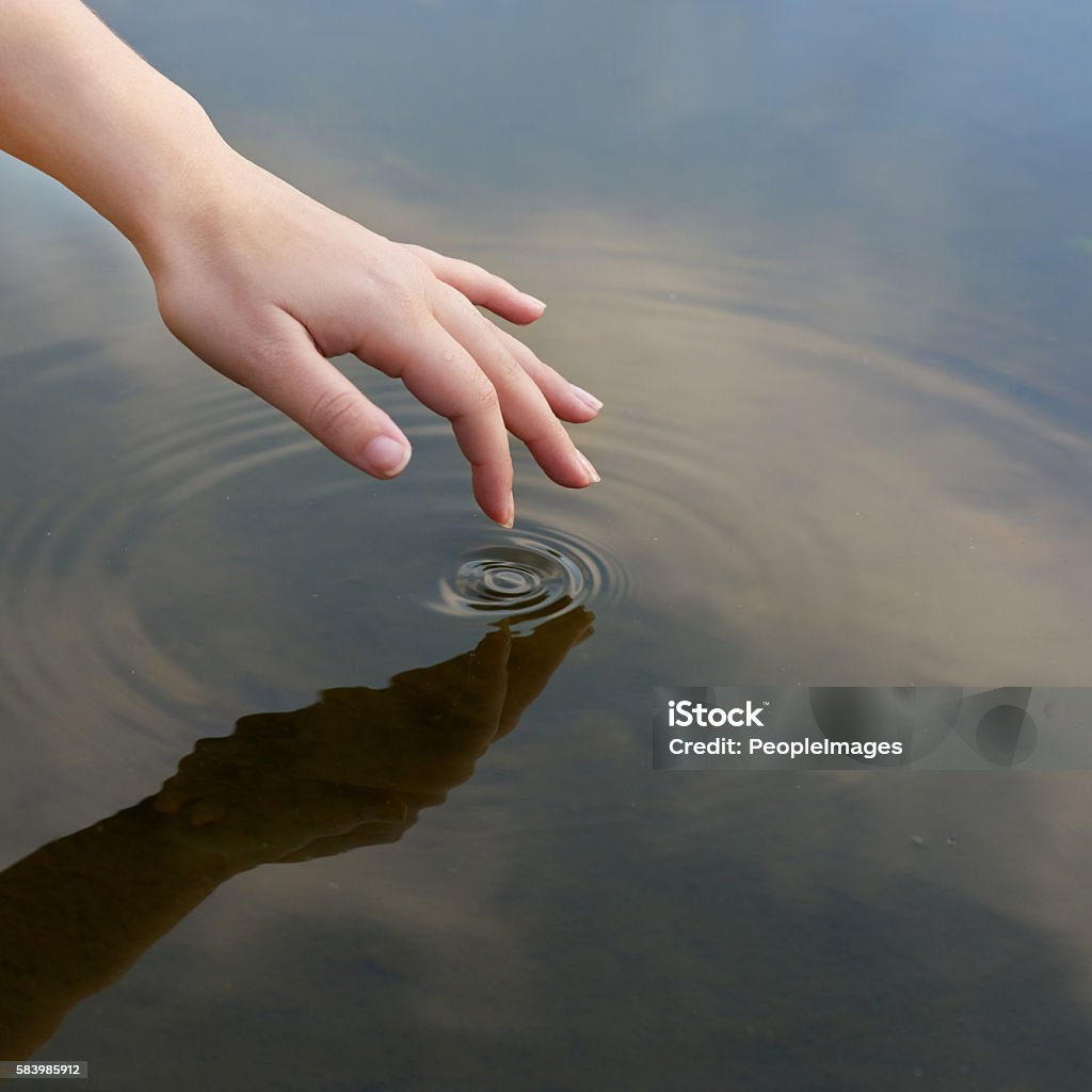 Patterns in a pond Cropped shot of a finger touching water to form ripples Water Stock Photo