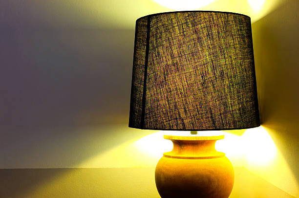 istock Lamp with Lampshade giving warm yellow light 583986636