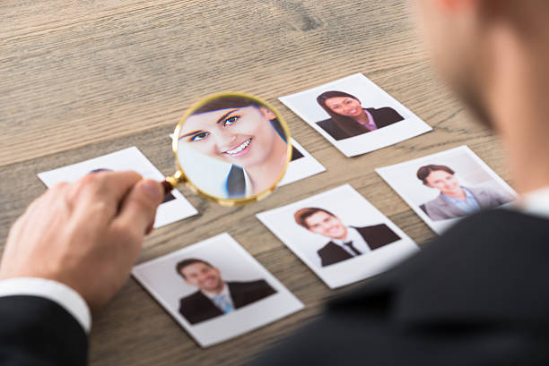 istock Businessman Viewing Candidates Through Magnifying Glass 583986750