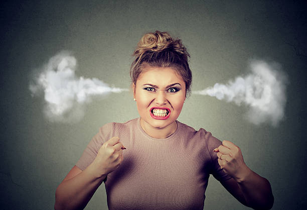 angry woman blowing steam coming out of ears - moppert stockfoto's en -beelden