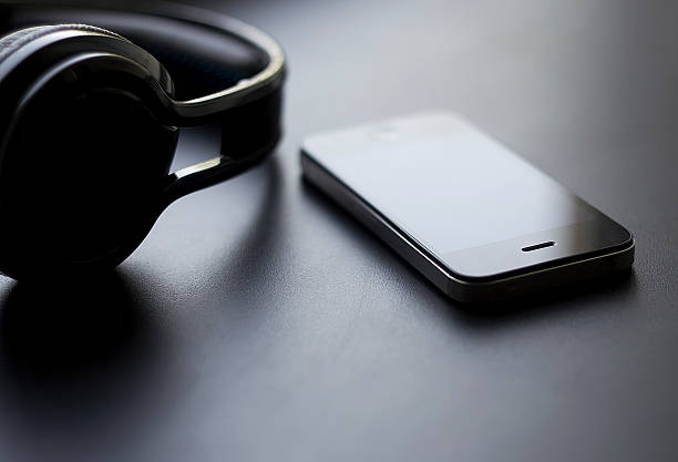 istock headphones and phone on a black background 583988450