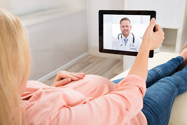 videoconferencia de mujer embarazada con el médico en la tableta digital - video conference camera fotografías e imágenes de stock
