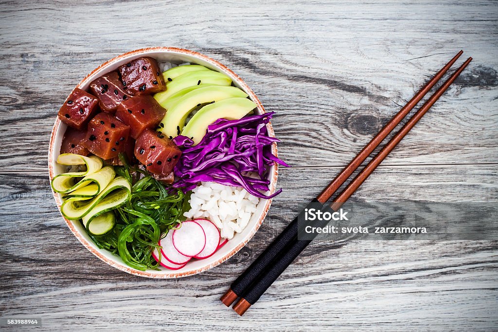 Hawaiian tuna poke bowl with seaweed, avocado, red cabbage, radishes Hawaiian tuna poke bowl with seaweed, avocado, red cabbage, radishes and black sesame seeds Poke - Food Stock Photo