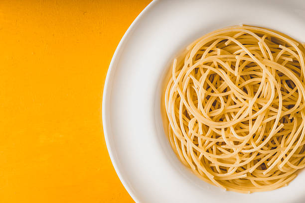 istock Spaghetti  on the white plate on yellow background top view 583989980