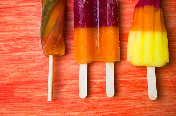istock Colorful ice lolly on a red wooden background 583990182