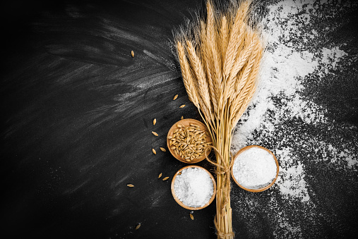 Wheat and flour on black background
