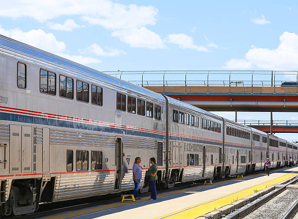 Waiting at the Station Albuquerque, United States - May 24, 2015: The Amtrak passenger train Southwest Chief at the station. Two women standing on the platform in front of it waiting for departure. Amtrak stock pictures, royalty-free photos & images