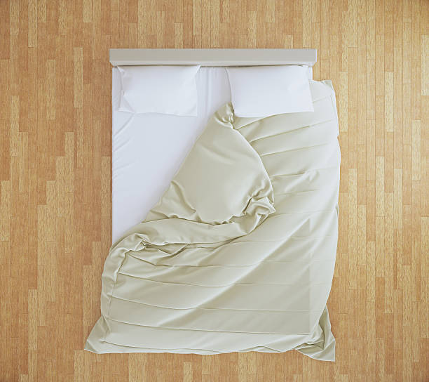 istock Unmade bed on wooden floor 583994432