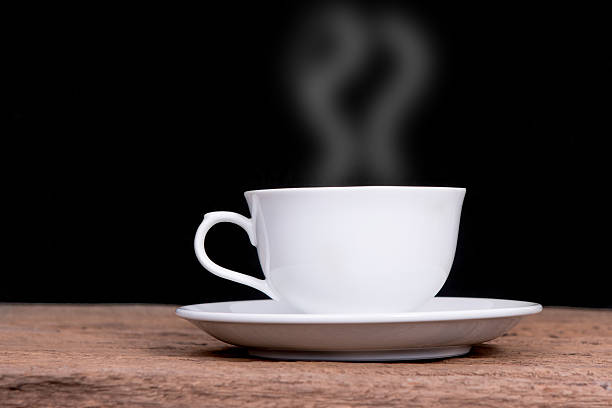 istock white cup with hot liquid and steam on black 583996274