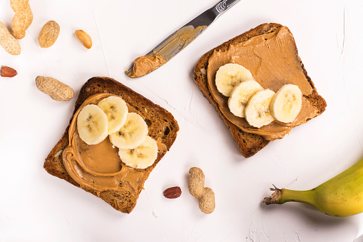 Peanut butter sandwiches with banana slices. Top view. Space for text