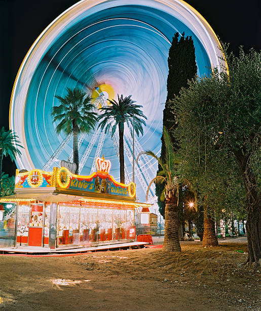 Nice, France Nice, France - December 04, 2008. The christmas fun fair with illuminated ferris wheel and vintage tiny gambling hut. Long exposure with analog  6x7 camera on negativ. christmas casino stock pictures, royalty-free photos & images