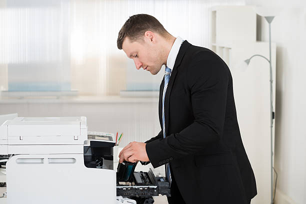 istock Businessman Adjusting Cartridge In Photocopy Machine 583999216