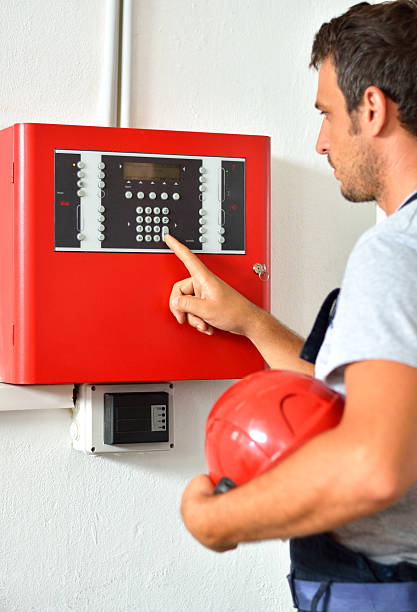 eletricista inspeciona o sistema de alarme de incêndio. - electricity control panel engineer electronics industry - fotografias e filmes do acervo