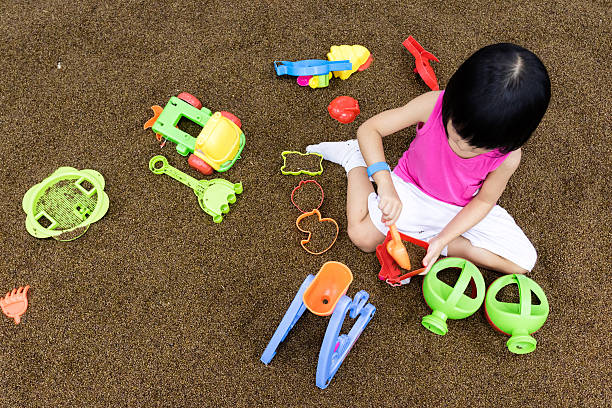 Asian Chinese Little Girl Playing with sand at indoor playground