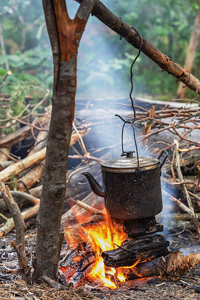 istock old iron kettle on fire. Cooking food in field conditions 584002300