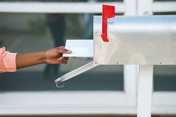 istock Person Putting Letters In Mailbox 584002574