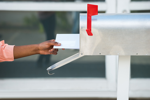 Close-up of closed yellow paper envelope on white background.