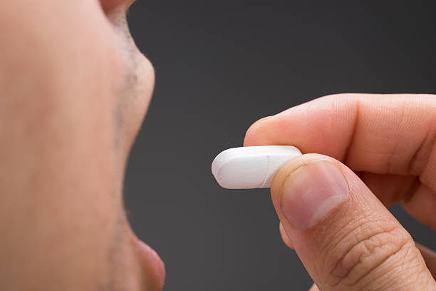 istock Sick Man Taking Medicine Against Gray Background 584004362