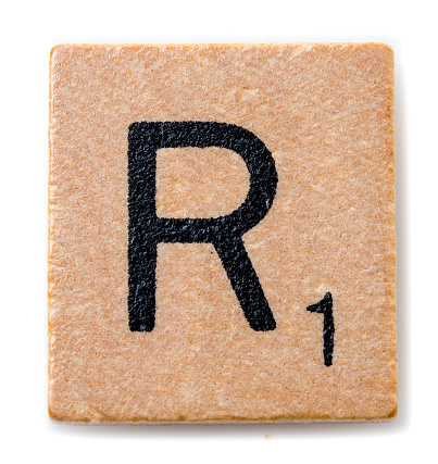 Miami, Florida, USA - December 7, 2015: Scrabble game board Lettered wooden tile showing the letter R. Scrabble is a fun and educational game distributed by Hasbro