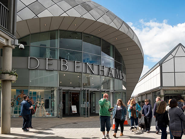 Branch of Debenhams, Bury St Edmunds Bury St Edmunds, Suffolk, England - April 17, 2016: People outside a Debenhams store in the modern Arc Shopping Centre in Bury St Edmunds, in Suffolk, eastern England. Bury St Edmunds is an ancient town, built around the Abbey which housed the shrine of King Edmund (St Edmund) and became a place of medieval pilgrimage. Today it is a popular place for tourists to explore and a thriving commercial centre for local people. bury st edmunds stock pictures, royalty-free photos & images