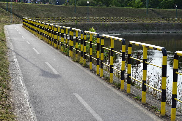 eingezäunter radweg am see - bicycle sign symbol bicycle lane stock-fotos und bilder