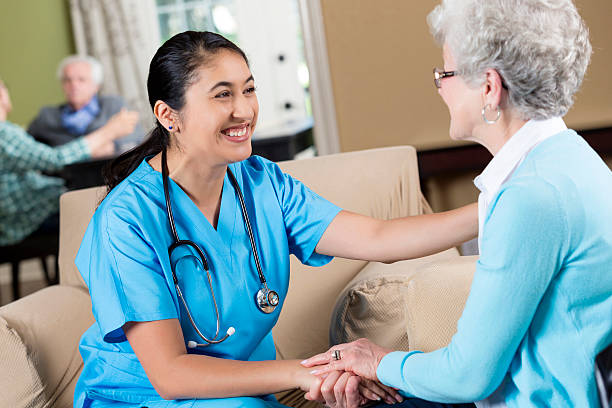 istock Helpful nurse smiling at her senior patient 584203874