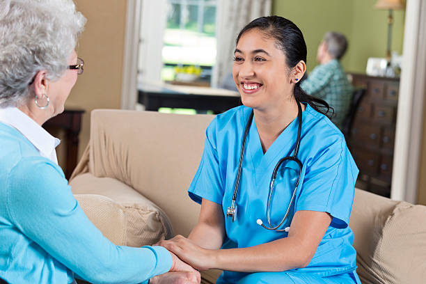 istock Happy Hispanic Nurse holding hands with a senior patient 584203928