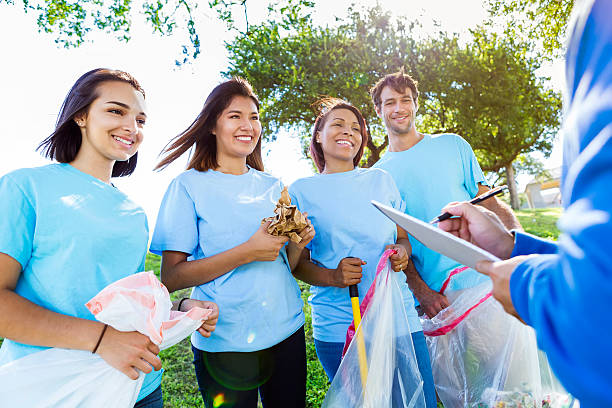istock Group of volunteers receive instruction before beginning community cleanup 584204358