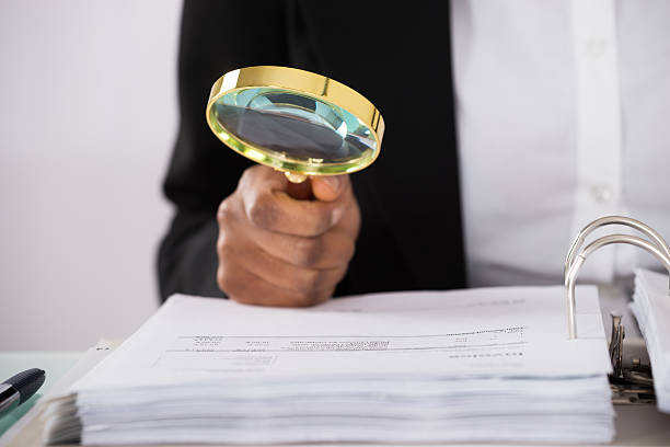 istock Businesswoman Hand Examining Invoice 584204396