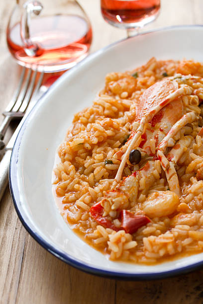 istock rice with seafood on white dish and pink wine 584205826