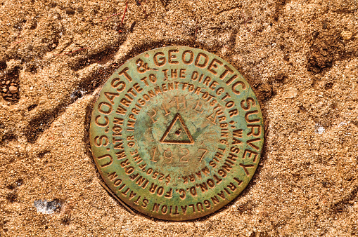 United States coast and geodetic survey triangulation reference marker located at Pihea Peak along Pihea trail near Kalalau valley on Kauai, Hawaii. They mark key survey points on the Earth's surface.