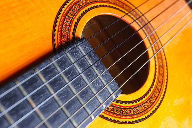 istock Strings, rose and neck of a yellow and orange guitar. 584207930