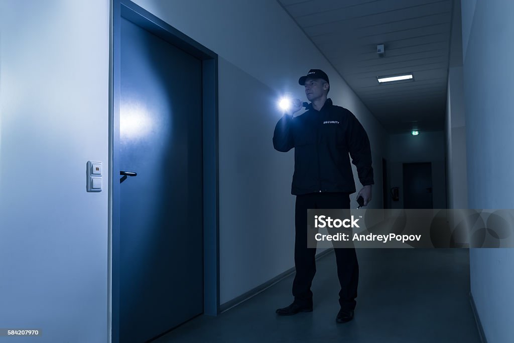 Sicherheitsmann mit Taschenlampe vor der Tür - Lizenzfrei Wachmann Stock-Foto