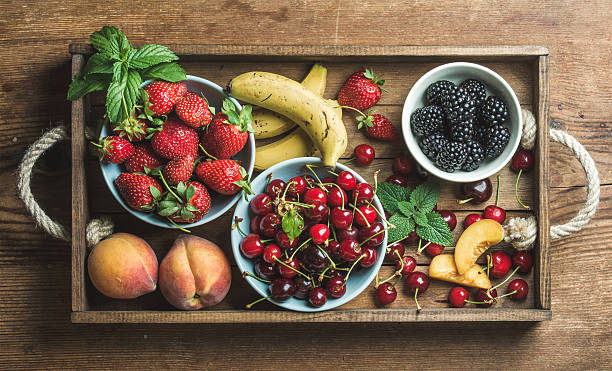 istock Summer fresh fruit and berry variety in rustic wooden tray 584209470