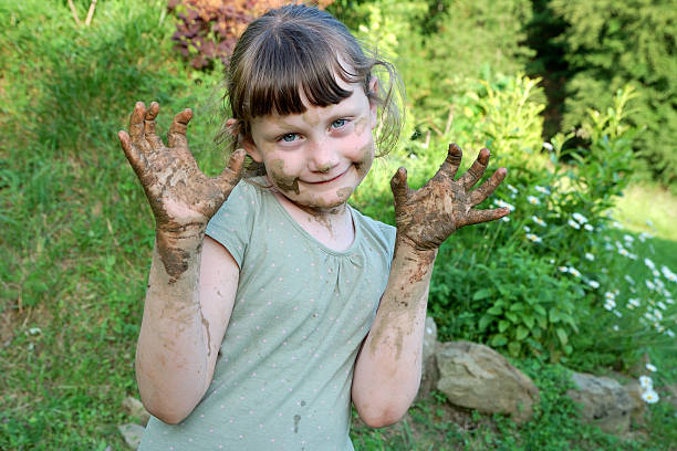 girl covered with mud a child with muddy hands and face people covered in mud stock pictures, royalty-free photos & images